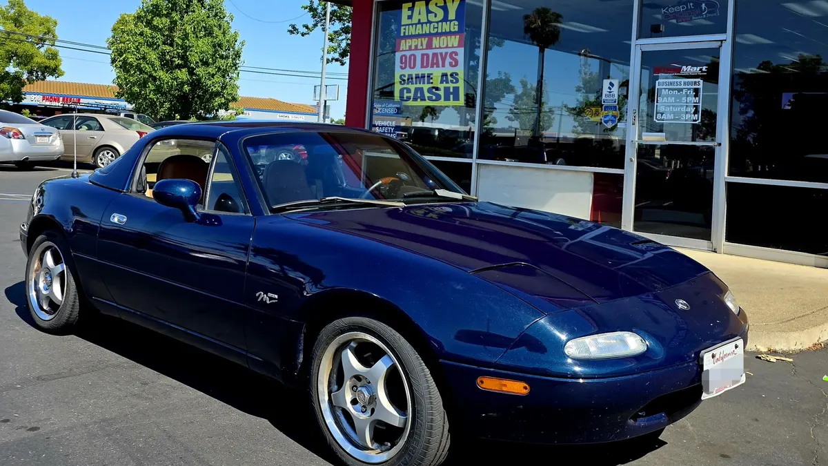 Convertible parked in the Sacramento sun outside Smog Mart